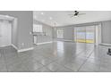 Open living room and kitchen area with grey tile floors and vaulted ceilings at 534 Bristol Cir, Kissimmee, FL 34758