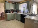 Galley kitchen with green cabinets and stainless steel appliances at 648 Tradewinds Dr, Deltona, FL 32738