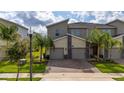 Two-story townhome with two-car garage and landscaped front yard at 701 Ocean Course Ave, Davenport, FL 33896