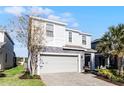 Two-story house with gray siding, stone accents, and a gray garage door at 8953 Zurich Ln, Kissimmee, FL 34747