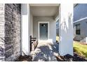 Covered front porch with gray brick flooring and a gray front door at 8953 Zurich Ln, Kissimmee, FL 34747