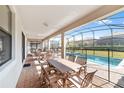 Screened patio with pool, table, chairs, and lounge chairs at 1455 Rolling Fairway Dr, Davenport, FL 33896