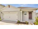 House exterior featuring a two-car garage and front door at 1516 Quinta Rd, Kissimmee, FL 34744