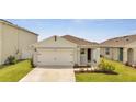 Newly built home with a two-car garage and well-manicured lawn at 1516 Quinta Rd, Kissimmee, FL 34744