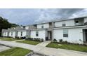 Row of townhouses with gray and white exteriors, and small yards at 2614 Old Kent Cir, Kissimmee, FL 34758