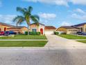 House exterior showcasing a two-car garage and palm tree at 3109 Harris Park Way, Kissimmee, FL 34758