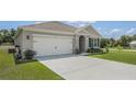 Tan house with a two-car garage and nicely manicured lawn at 362 Alexzander Way, Winter Haven, FL 33881