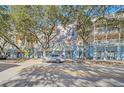 Three story building with light blue exterior and balconies along a tree-lined street at 651 Celebration Ave # 651, Celebration, FL 34747