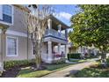 Tan townhome with a balcony and walkway, surrounded by trees and shrubs at 7136 Red Lantern Dr # 7136, Harmony, FL 34773