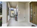Covered front porch with white railing and small plant stand at 7136 Red Lantern Dr # 7136, Harmony, FL 34773