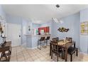 Dining area with a dark brown table and chairs, adjacent to a kitchen and entryway at 1017 Park Ridge Cir, Kissimmee, FL 34746