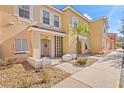 Side view of a two-story tan building with white shutters, palm trees, and a walkway at 1017 Park Ridge Cir, Kissimmee, FL 34746