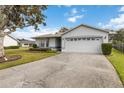 Front view of a house with a white garage door and landscaping at 1403 Sean Ct, St Cloud, FL 34772