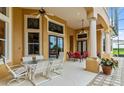 Covered patio with seating area and dining table, adjacent to the house at 1515 Sunset Pointe Pl, Kissimmee, FL 34744