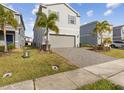Two-story house with gray siding, two-car garage, and a landscaped front yard at 1607 Kona Ln, Davenport, FL 33897