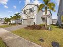 Two-story house with gray siding, two-car garage, and a landscaped front yard at 1607 Kona Ln, Davenport, FL 33897