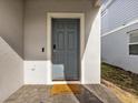 Gray front door with a welcome mat and keypad entry at 1607 Kona Ln, Davenport, FL 33897