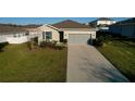 Charming single-story home featuring a two-car garage and a well-maintained front lawn at 2587 Summer Star Way, Leesburg, FL 34748