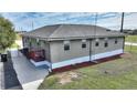 Grey house with red door and walkway, surrounded by landscaping at 3610 Old Berkley Rd, Auburndale, FL 33823
