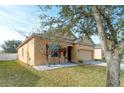 Tan house with a two-car garage and landscaping at 5589 Sycamore Canyon Dr, Kissimmee, FL 34758