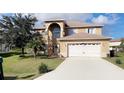 Charming, two-story home showcasing a well-maintained lawn, arched entryway, and attached two-car garage at 570 Bristol Cir, Kissimmee, FL 34758