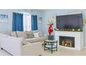 Cozy living room with a decorative fireplace, a comfortable couch, blue curtains, and soft, blue-painted walls at 570 Bristol Cir, Kissimmee, FL 34758