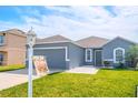 Charming single-Gathering home featuring well-kept lawn and modern gray exterior at 6144 Forest Ridge Way, Winter Haven, FL 33881