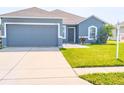 Charming one-story home with a well-manicured lawn, two car garage, and neutral blue paint at 6144 Forest Ridge Way, Winter Haven, FL 33881