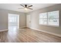 Bright living room with wood-look floors and access to sunroom at 645 King St, Eustis, FL 32726