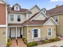 Attractive tan townhome with a brown roof, landscaping, and walkway at 7591 Sunny Dreams Ln, Kissimmee, FL 34747