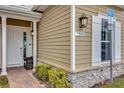 Townhome entrance with a white door, brick walkway, and lamp at 7591 Sunny Dreams Ln, Kissimmee, FL 34747