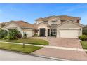 Two-story house with a three-car garage and brick driveway, under a clear blue sky at 900 Windlass Ct, Kissimmee, FL 34746