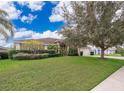 House with green lawn, landscaping, and a large tree at 11322 Bronson Rd, Clermont, FL 34711