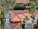 Top-down view of home with tile roof, pool, and surrounding landscape at 220 Brunello Dr, Davenport, FL 33897
