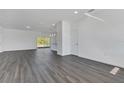 Open living room with gray vinyl plank flooring and kitchen access at 223 Elm Ct, Kissimmee, FL 34759
