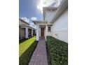 Inviting front entry with red door and brick walkway at 2438 Yellow Brick Rd, St Cloud, FL 34772
