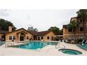 Resort-style pool and hot tub with lounge chairs and umbrella-covered tables for relaxation at 3004 Parkway Blvd # 208, Kissimmee, FL 34747