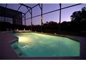 Inviting screened pool and spa at night with lighting at 4626 Cumbrian Lakes Dr, Kissimmee, FL 34746