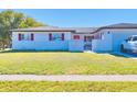 Single story home with red accents and a landscaped lawn at 7438 Wayland Blvd, Orlando, FL 32807