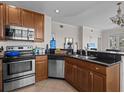 Modern kitchen featuring stainless steel appliances and dark wood cabinets at 7509 Mourning Dove Cir # 304, Reunion, FL 34747