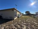 Rear view of house showing a mostly empty yard at 869 Colville Dr, Kissimmee, FL 34759