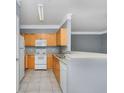 Bright kitchen with light wood cabinets and white appliances at 8848 Villa View # 106, Orlando, FL 32821