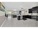 Modern kitchen with black cabinets, stainless steel appliances, and an island at 9194 Sommerset Hills Dr, Davenport, FL 33896