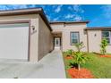 Inviting front entrance with tidy landscaping, modern design, and manicured green grass at 9505 Luna Dr, St Cloud, FL 34773