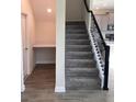 Staircase with grey carpeting, black railing, and built-in desk at 1144 Trappers Trail Loop, Davenport, FL 33896