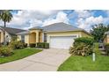 Eye-catching yellow house with a gray roof, and well-maintained lawn at 135 Langham Dr, Davenport, FL 33897