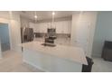 Modern kitchen with white cabinets, quartz countertops, and stainless steel appliances at 1511 Woodmont Blvd, Kissimmee, FL 34746