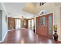 Welcoming foyer with high ceilings, beautiful front door with glass accents, and hardwood floors at 212 Rontunda Dr, Kissimmee, FL 34758