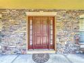 Solid wood front door with glass accents, and stone surround at 3085 Mandolin Dr, Kissimmee, FL 34744