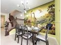 Charming dining room with a dinosaur mural, a six-chair table, and a modern light fixture at 3878 Lana Ave, Davenport, FL 33897